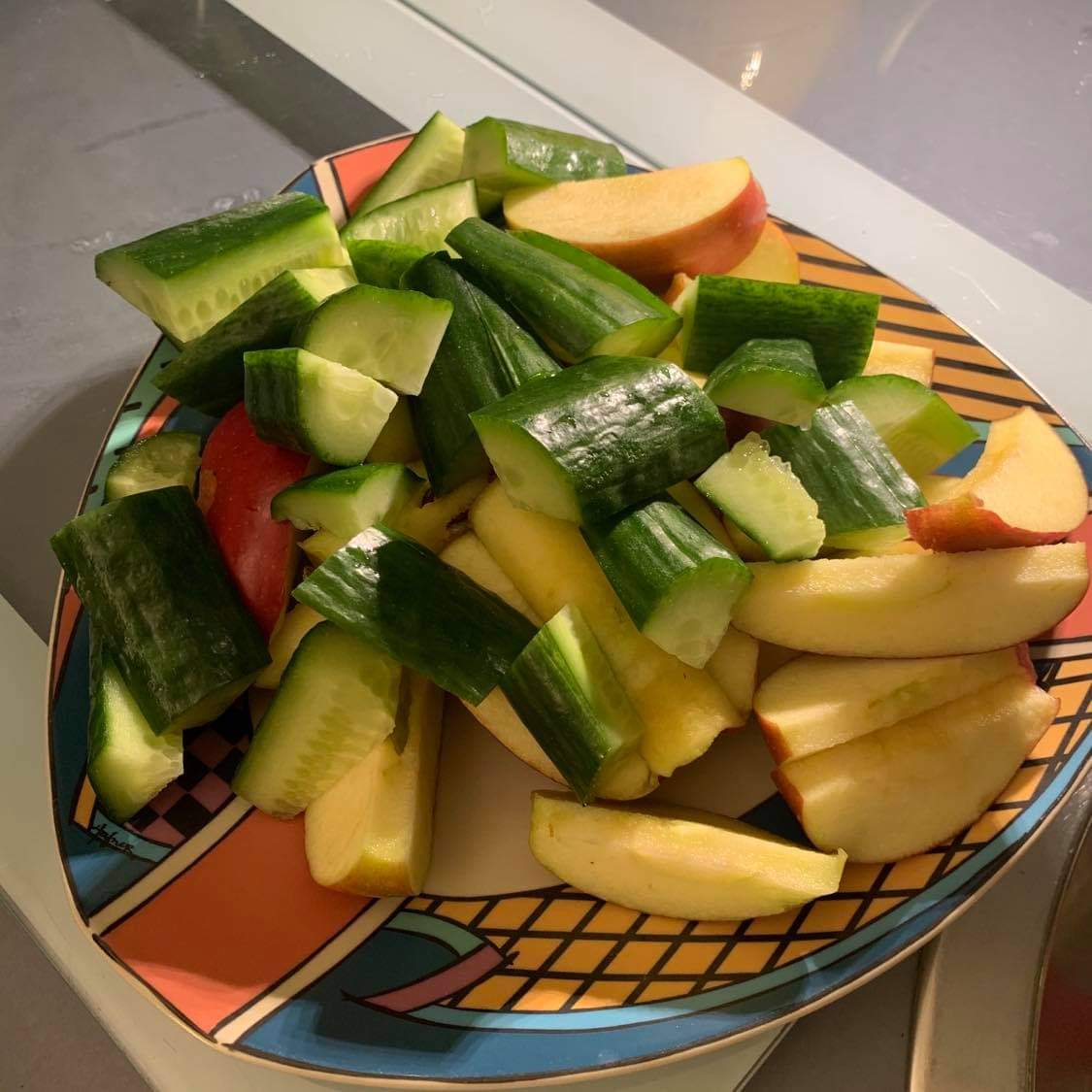 Schneller Snack aus Gurkenstücken und Apfelspalten Gurken- und Apfelschnitze auf Teller